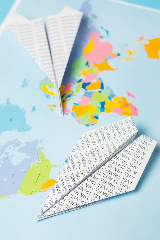 Paper planes flying over a map, symbolising international digital strategy and travel