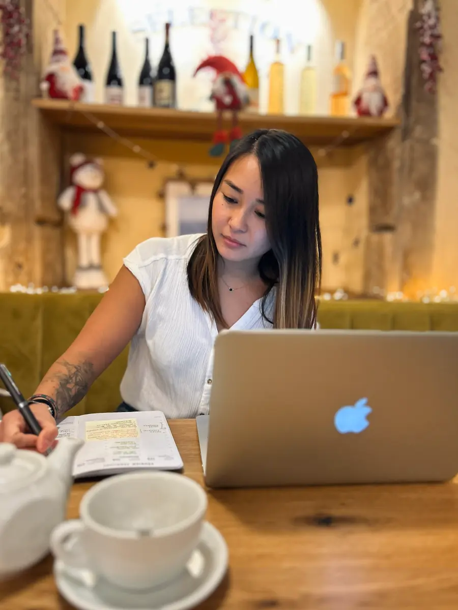 Léa Servais writing multilingual content in a café